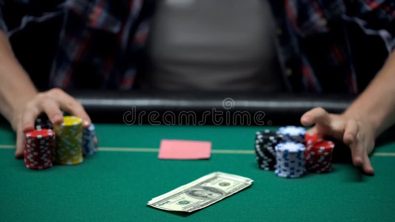 Pokerspelaren som slå vad dollar, och alla hans kasinochiper i kort spelar och att spela royaltyfria foton Pokerspelaren som slå vad dollar, och alla hans kasinochiper i kort spelar och att spela royaltyfria foton