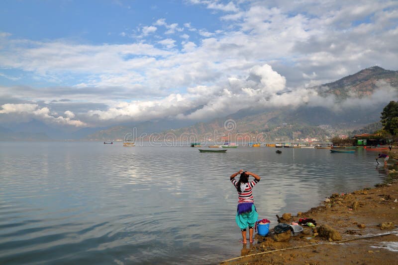 POKHARA, NEPAL: Nepalski kobiety domycie odziewa wzdłuż brzeg Phewa jezioro fotografia stock POKHARA, NEPAL: Nepalski kobiety domycie odziewa wzdłuż brzeg Phewa jezioro fotografia stock
