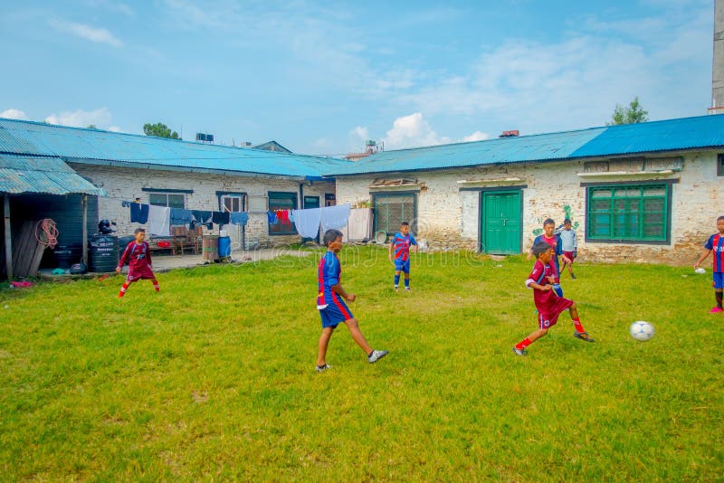 POKHARA, NÉPAL - 6 OCTOBRE 2017 : Enfants non identifiés jouant le football dans une arrière-cour et portant des uniformes, près photo libre de droits POKHARA, NÉPAL - 6 OCTOBRE 2017 : Enfants non identifiés jouant le football dans une arrière-cour et portant des uniformes, près photo libre de droits