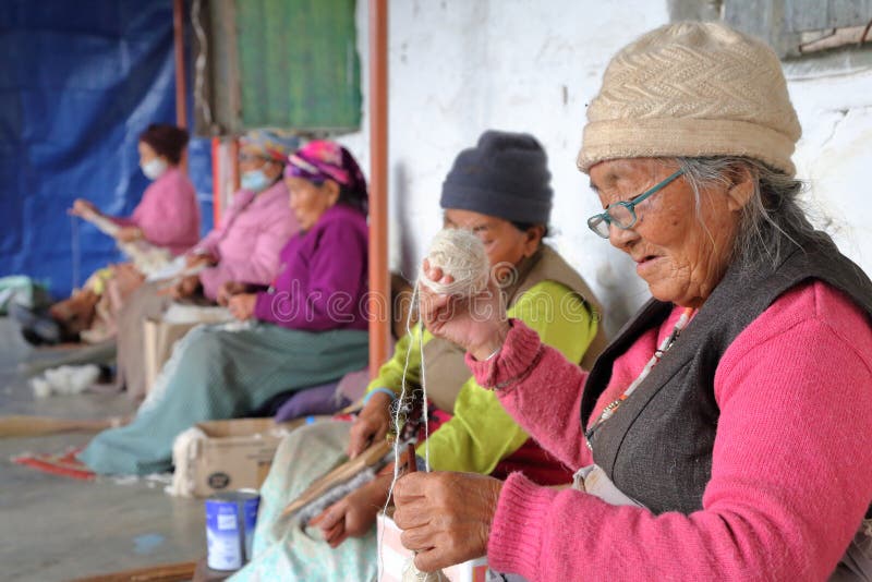 POKHARA, НЕПАЛ - 8-ОЕ ЯНВАРЯ 2015: Тибетские женщины закручивая шерсти на лагерь беженцев тибетца Tashi Palkhel стоковое фото POKHARA, НЕПАЛ - 8-ОЕ ЯНВАРЯ 2015: Тибетские женщины закручивая шерсти на лагерь беженцев тибетца Tashi Palkhel стоковое фото