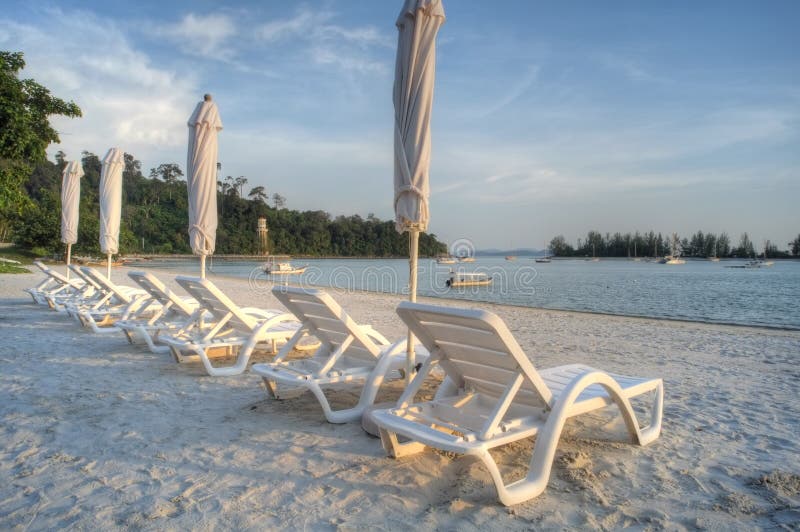 Pokładu krzesła i plażowi parasole na plaży zdjęcie royalty free Pokładu krzesła i plażowi parasole na plaży zdjęcie royalty free