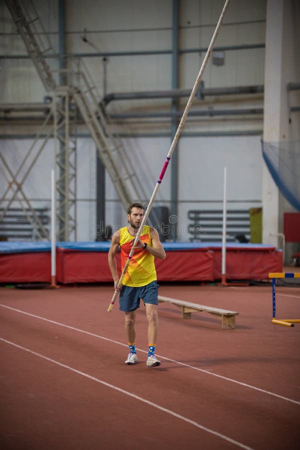 Pole Vaulting Indoors a Man Standing on the Track with a Pole Stock