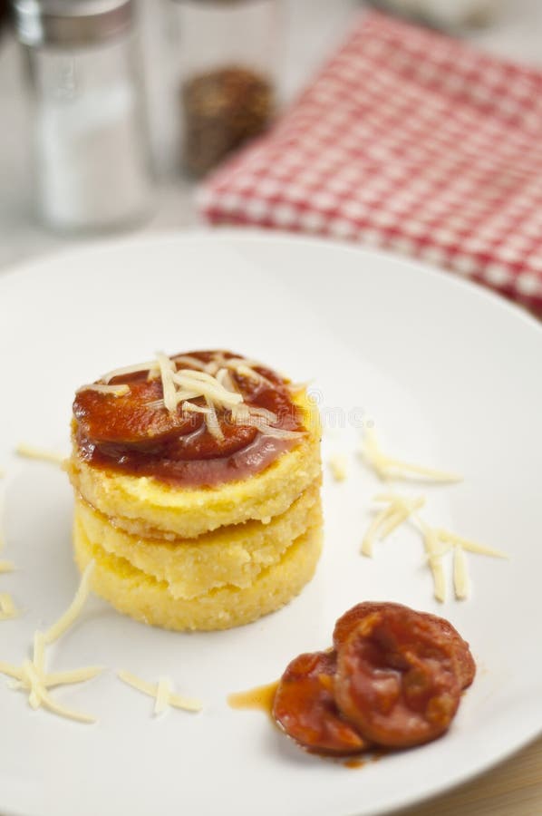 Cornmeal (polenta) withsausage and tomato sauce with blurry background. Cornmeal (polenta) withsausage and tomato sauce with blurry background