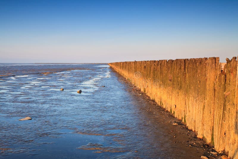 Poles in the ocean at sunset