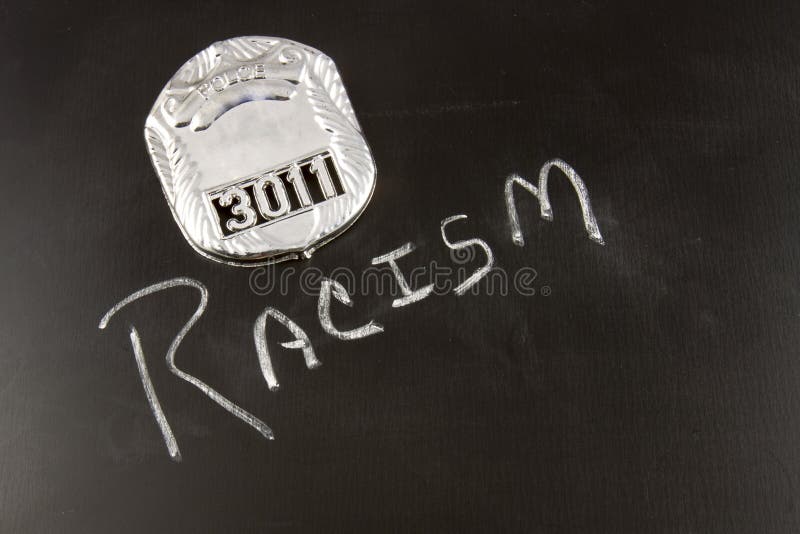 The word RACISM on a chalkboard with a police badge. The word RACISM on a chalkboard with a police badge