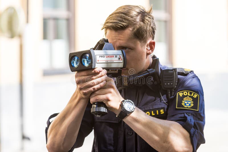 Police officer performing measurement with speed enforcement laser. Stockholm, Sweden. Police officer performing measurement with speed enforcement laser. Stockholm, Sweden.