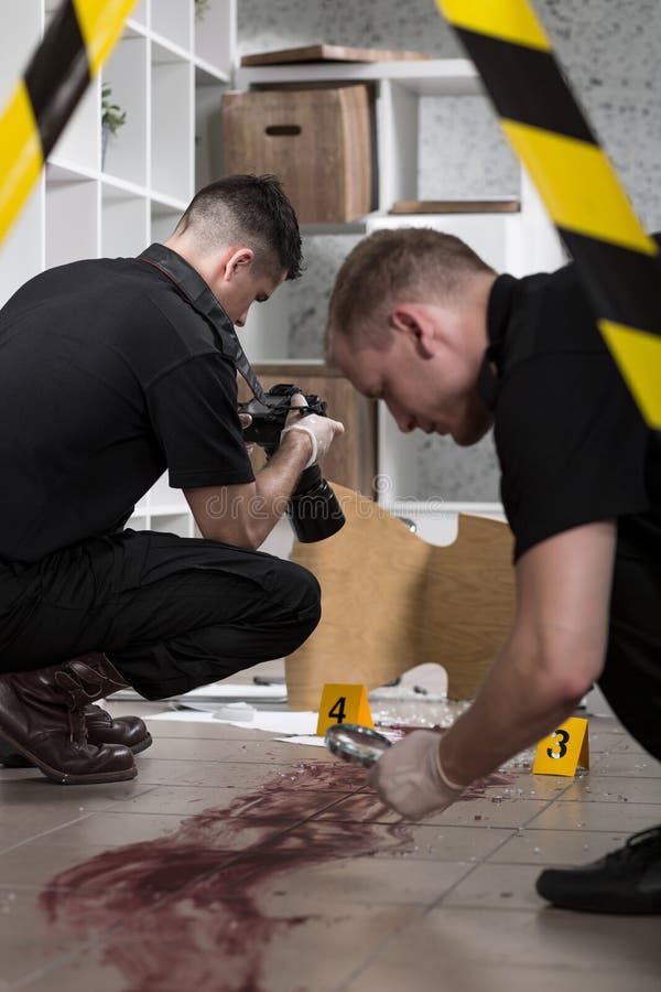 Close-up of policemen working at the murder scene. Close-up of policemen working at the murder scene