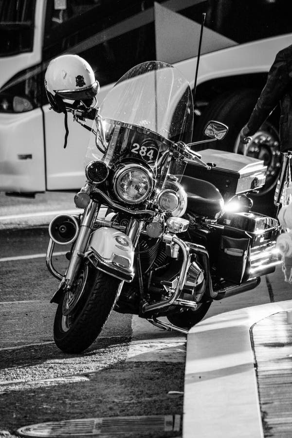 Policie a motocicleta preta moderna estacionada no passeio