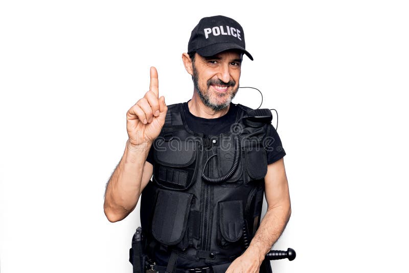 Policía de mediana edad con uniforme de policía y chaleco antibalas sobre fondo blanco sonriendo con una idea o pregunta señalando foto de archivo
