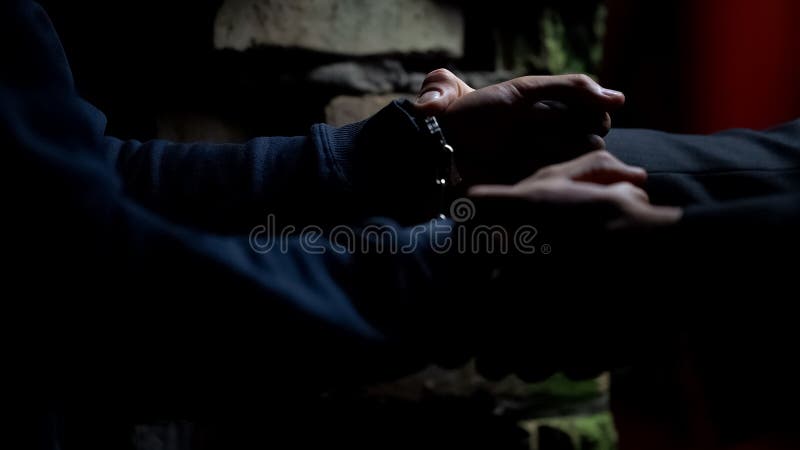Policía que pone las esposas en traficante en la casa abandonada, criminal de cogida foto de archivo libre de regalías Policía que pone las esposas en traficante en la casa abandonada, criminal de cogida foto de archivo libre de regalías