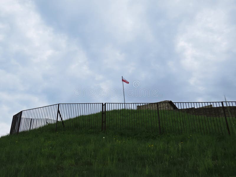 Polish Flag in Wind on a Tower of Stronghold with Clouds in Background