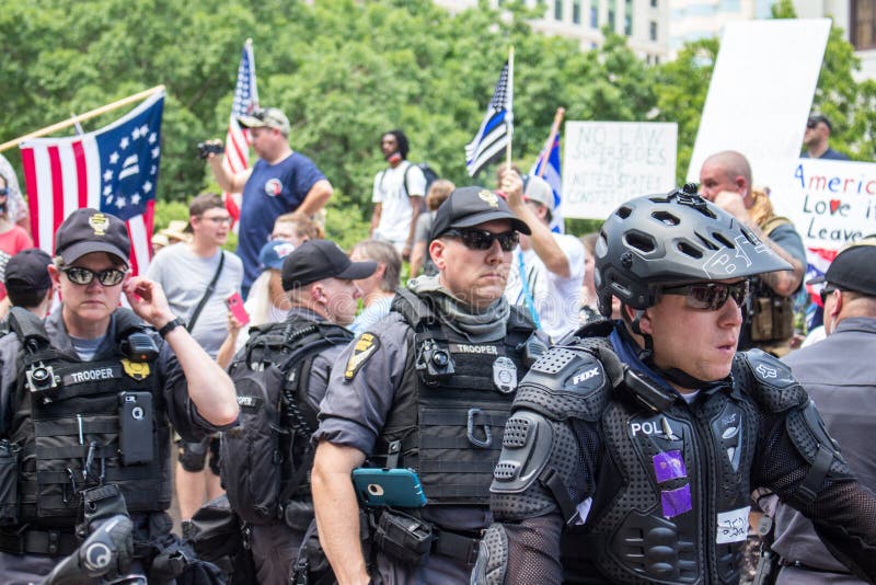 Police officers line up to get between pro-Trump/police demonstrators and a crowd of BLM counter protestors at a conservative rally in support of police, Donald Trump, and against mask mandates. Downtown Columbus Ohio. July 18th 2020. Police officers line up to get between pro-Trump/police demonstrators and a crowd of BLM counter protestors at a conservative rally in support of police, Donald Trump, and against mask mandates. Downtown Columbus Ohio. July 18th 2020.