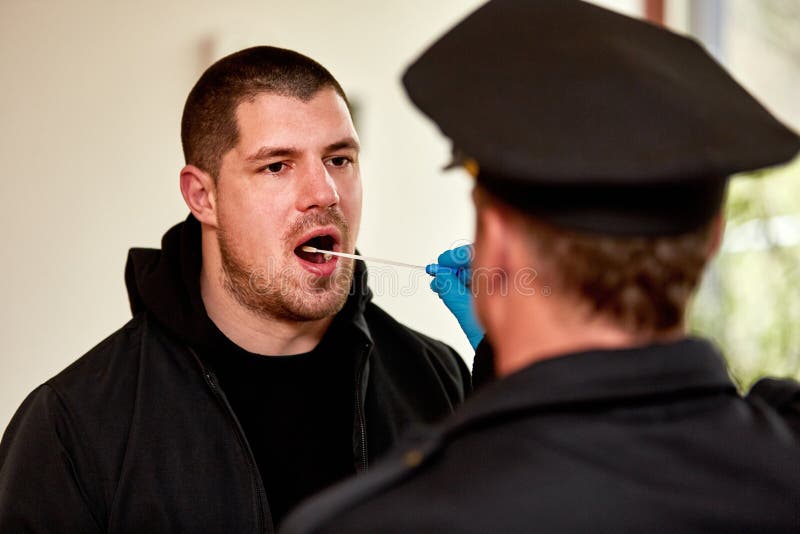 Poliziotto che preleva il campione della saliva come prova del DNA