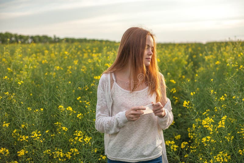 Pollen allergy, girl sneezing in a rapeseed field of flowers