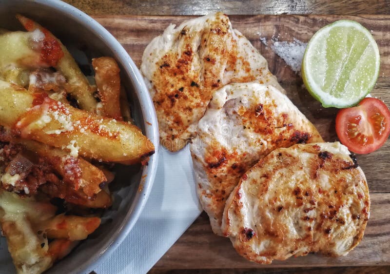 Pollo asado a la parrilla del pecho con el microprocesador caseoso fotografía de archivo libre de regalías Pollo asado a la parrilla del pecho con el microprocesador caseoso fotografía de archivo libre de regalías