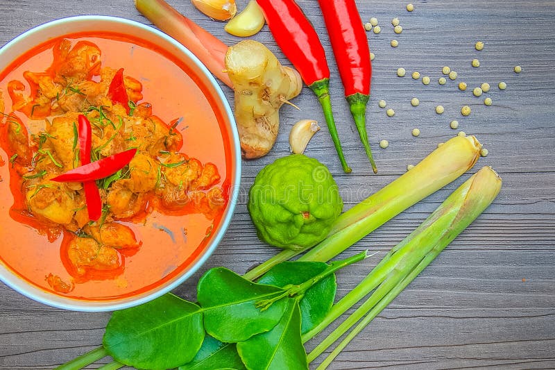 Pollo rosso del curry, alimento piccante tailandese ed ingredienti freschi dell'erba sopra