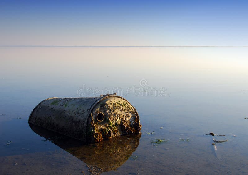 Priemyselného odpadu ponechané na pobreží veľkého znečistenia foto za súmraku.