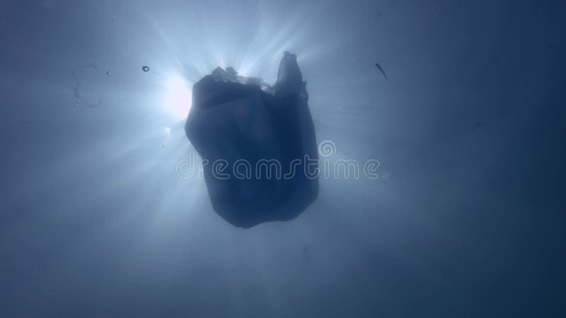 Pollution en plastique, un sac en plastique bleu jeté découlant lentement les rayons sous-marins de surface au soleil Photo sous- clips vidéos