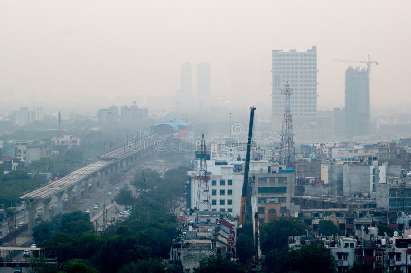Pollution in Noida Delhi against the cityscape. Delhi, India - 8th Jan 2017: Pollution, fog and smog in Noida during the winters against the cityscape stock photography Pollution in Noida Delhi against the cityscape. Delhi, India - 8th Jan 2017: Pollution, fog and smog in Noida during the winters against the cityscape stock photography