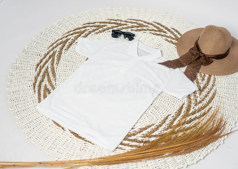 A polo shirt laid out on the top of a rattan rug with minimalist decoration
