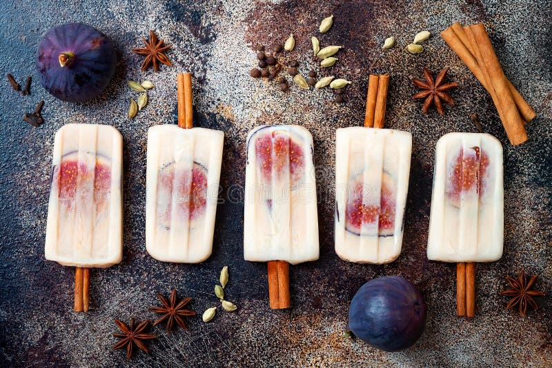 Masala chai latte popsicles with figs on cinnamon sticks. Spiced ice lollies for fall and winter season. Christmas holiday dessert. Masala chai latte popsicles with figs on cinnamon sticks. Spiced ice lollies for fall and winter season. Christmas holiday dessert