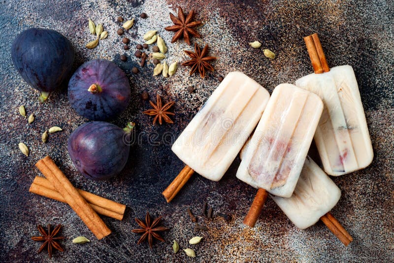 Masala chai latte popsicles with figs on cinnamon sticks. Spiced ice lollies for fall and winter season. Christmas holiday dessert. Masala chai latte popsicles with figs on cinnamon sticks. Spiced ice lollies for fall and winter season. Christmas holiday dessert