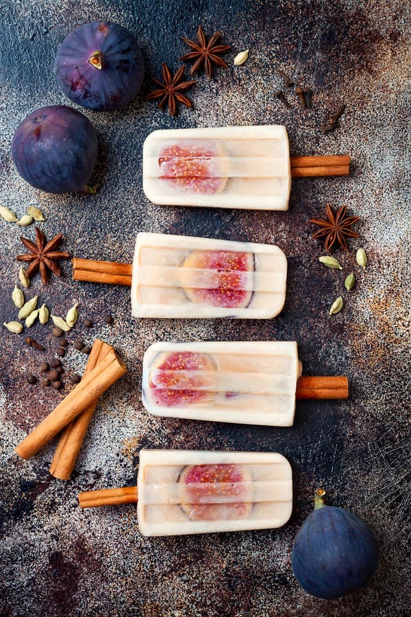 Masala chai latte popsicles with figs on cinnamon sticks. Spiced ice lollies for fall and winter season. Christmas holiday dessert. Masala chai latte popsicles with figs on cinnamon sticks. Spiced ice lollies for fall and winter season. Christmas holiday dessert