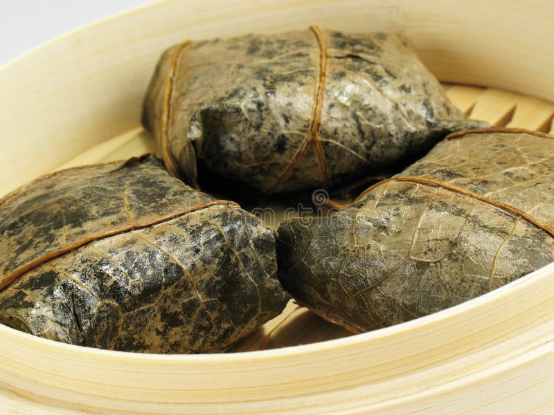 Steamed Chinese rice dumplings wrapped in lotus leaves, filled with glutinous/sticky rice, mushrooms, and dried shrimp. Steamed Chinese rice dumplings wrapped in lotus leaves, filled with glutinous/sticky rice, mushrooms, and dried shrimp.