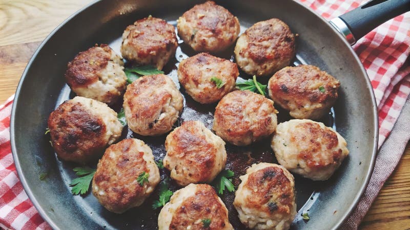 Polpette di carne di maiale fritte che ronzano in una pentola con erbe fresche e panno in scatola in cucina. aizione generativa illustrazione di stock