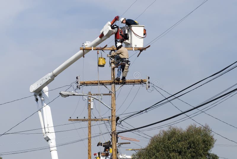 Men working on a transformer on a electricity power pole. Men working on a transformer on a electricity power pole