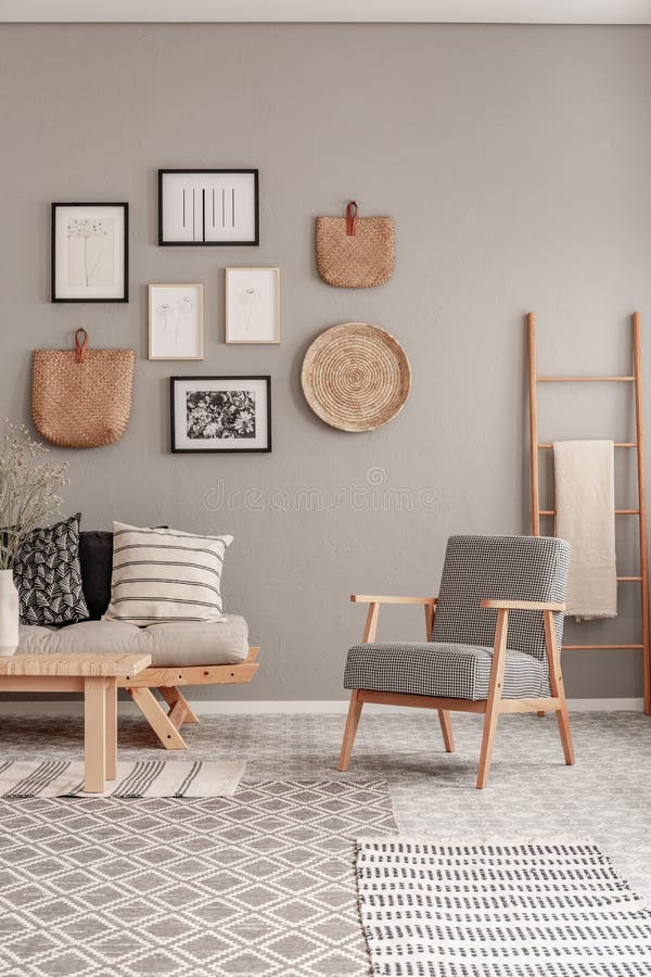 Poltrona na moda do vintage ao lado do sofá escandinavo chique com os descansos no interior elegante da sala de visitas fotografia de stock Poltrona na moda do vintage ao lado do sofá escandinavo chique com os descansos no interior elegante da sala de visitas fotografia de stock