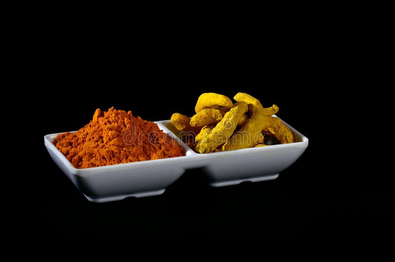 Polvere e radici asciutte della curcuma fotografia stock libera da diritti Polvere e radici asciutte della curcuma fotografia stock libera da diritti