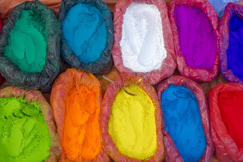 Polveri multicolori molto luminose di una pittura in borse ed in un piccolo cucchiaio pitture per la festa di Holi fotografia stock Polveri multicolori molto luminose di una pittura in borse ed in un piccolo cucchiaio pitture per la festa di Holi fotografia stock