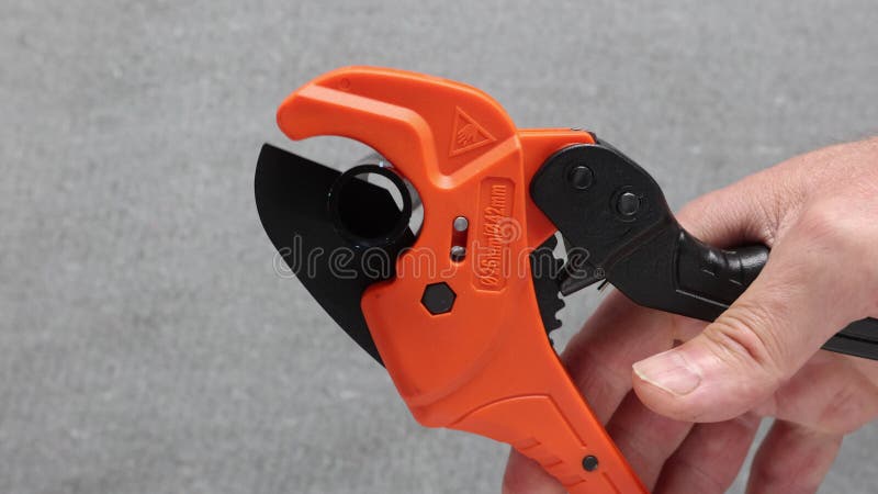 Plastic pipe cutter with ratchet cuts polyethylene pipe. stock video footage