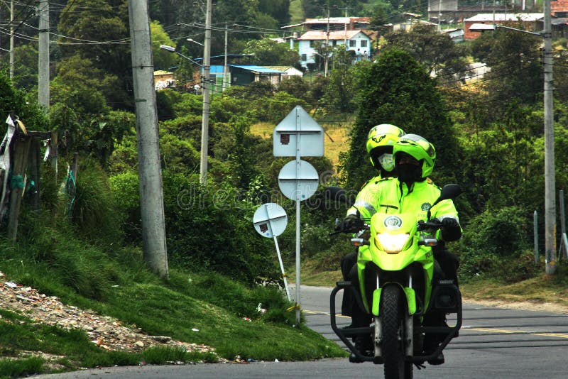 A couple of police patrolling the roads around bogota, protected with masks, and enforcing the mandatory isolation. A couple of police patrolling the roads around bogota, protected with masks, and enforcing the mandatory isolation.