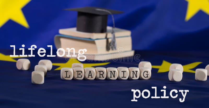 Words LIFELONG  LEARNING POLICY composed of wooden letters.  Black graduate hat on EU flag in the background. Closeup. Words LIFELONG  LEARNING POLICY composed of wooden letters.  Black graduate hat on EU flag in the background. Closeup