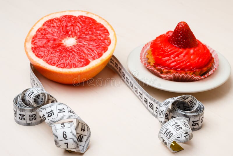 Pomelo y torta con la cinta métrica Dieta foto de archivo libre de regalías Pomelo y torta con la cinta métrica Dieta foto de archivo libre de regalías