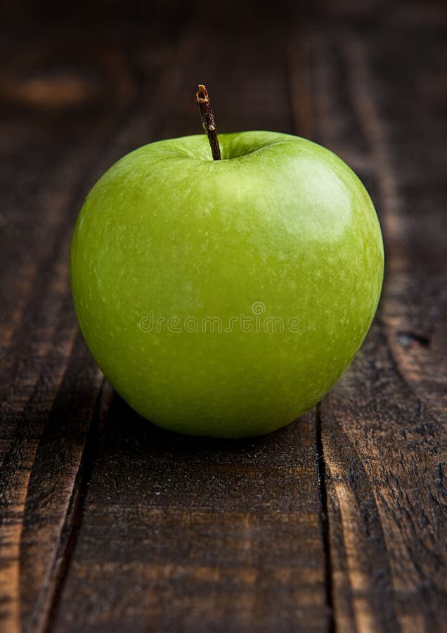 Pomme saine organique verte sur le conseil en bois image libre de droits Pomme saine organique verte sur le conseil en bois image libre de droits