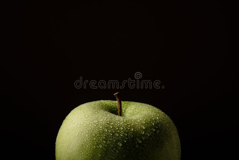 Pomme verte avec des baisses de l'eau sur un fond noir image libre de droits Pomme verte avec des baisses de l'eau sur un fond noir image libre de droits