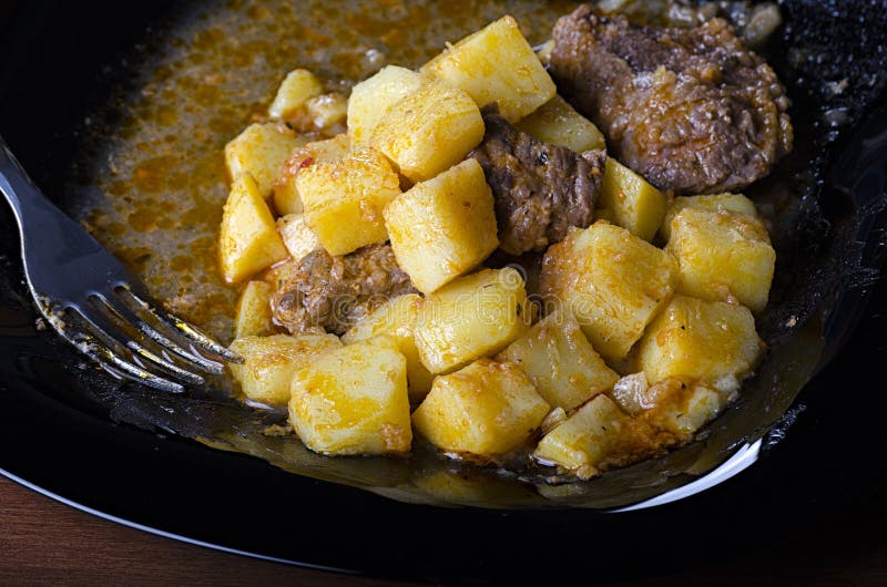 Pommes de terre braisées avec de la viande et la sauce au jus d'un plat noir, vue du plan rapproché 45 photos libres de droits Pommes de terre braisées avec de la viande et la sauce au jus d'un plat noir, vue du plan rapproché 45 photos libres de droits