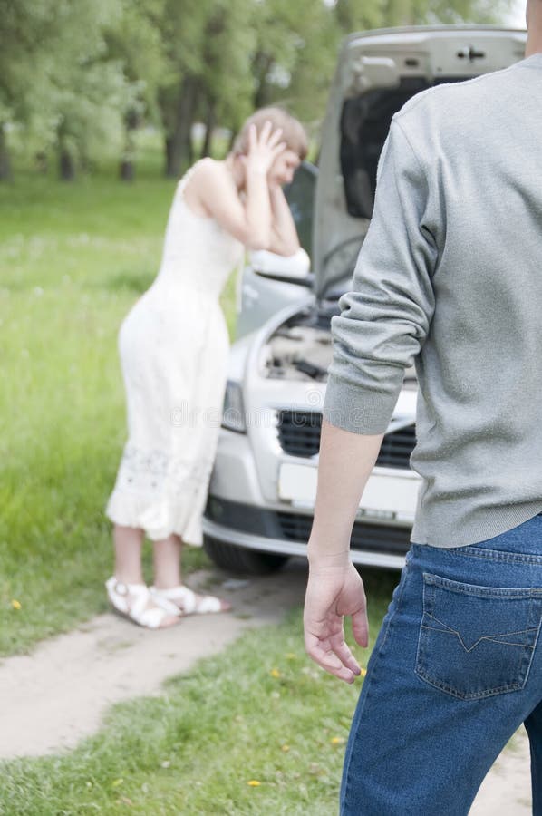 Male back with worried young woman near her broken car. Male back with worried young woman near her broken car