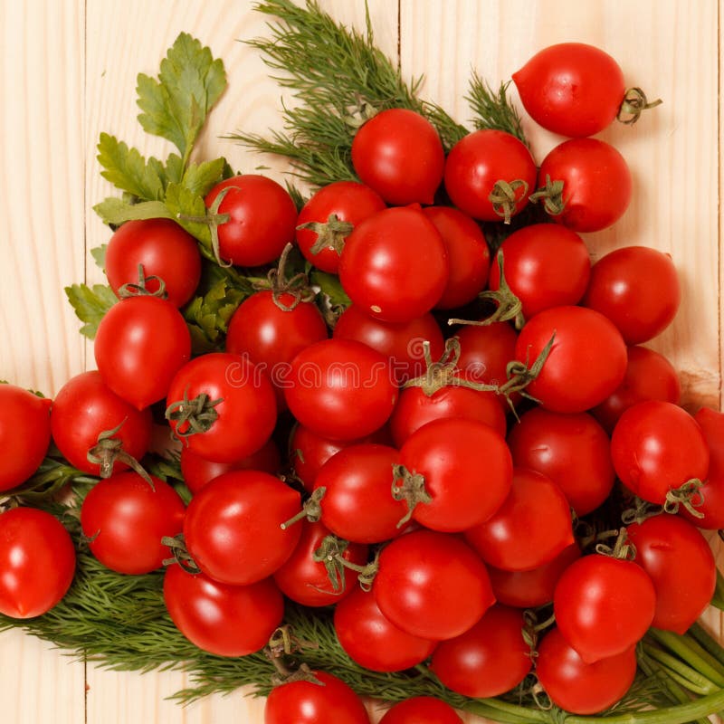 Pomodori ciliegia ed erbe fresche su fondo di legno fotografia stock Pomodori ciliegia ed erbe fresche su fondo di legno fotografia stock