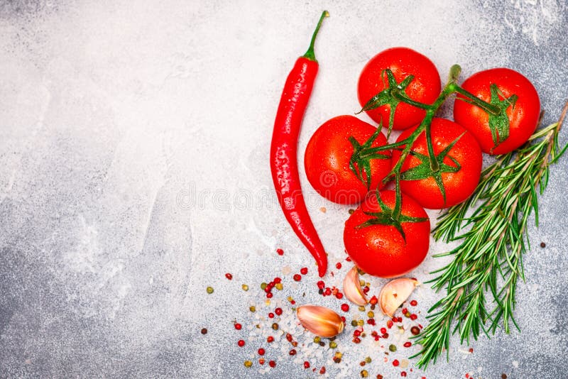 Pomodori maturi succosi freschi su un ramo, su un peperone, sui rosmarini, su un aglio e sulle spezie fotografie stock libere da diritti Pomodori maturi succosi freschi su un ramo, su un peperone, sui rosmarini, su un aglio e sulle spezie fotografie stock libere da diritti