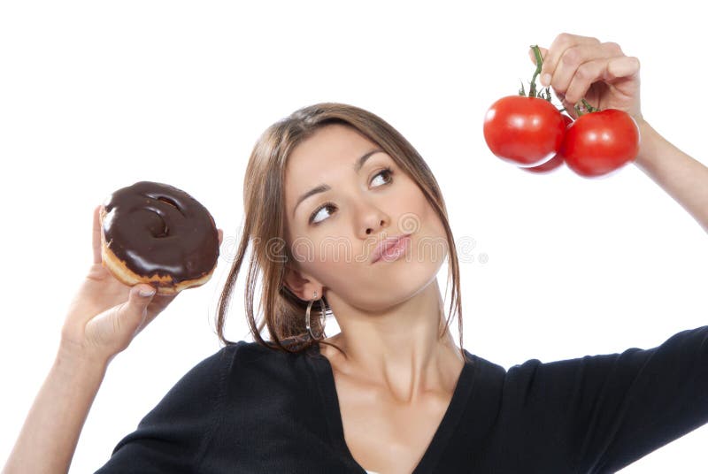 Healthy eating food concept. Woman comparing unhealthy donut and organic red tomatoes, thinking isolated on a white background. Healthy eating food concept. Woman comparing unhealthy donut and organic red tomatoes, thinking isolated on a white background