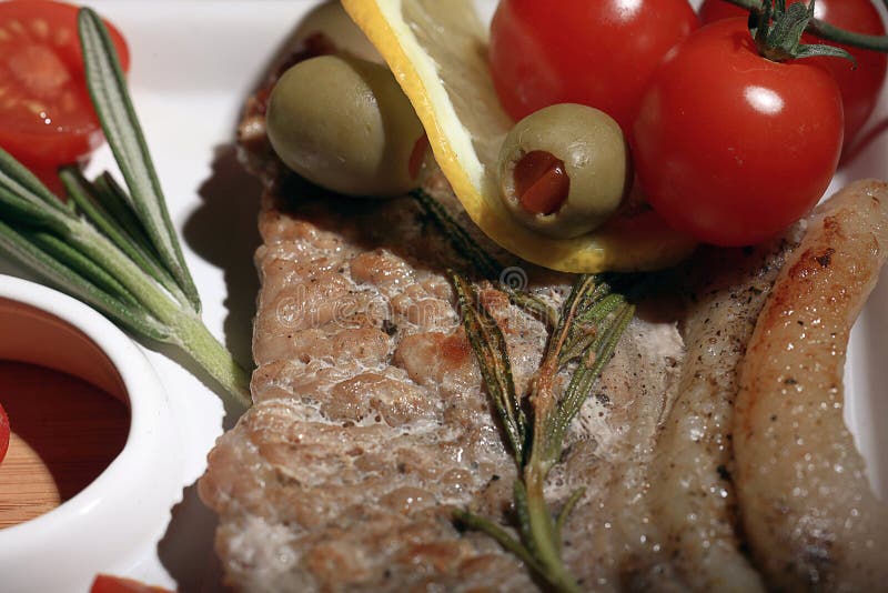 Pomodori su una carne del piatto immagine stock Pomodori su una carne del piatto immagine stock