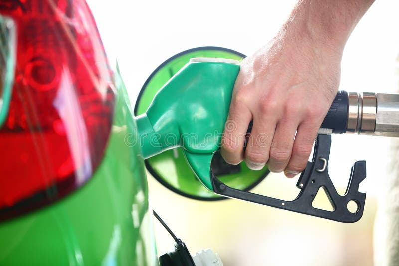 Pompa della stazione di servizio - benzina di riempimento in automobile verde fotografie stock Pompa della stazione di servizio - benzina di riempimento in automobile verde fotografie stock
