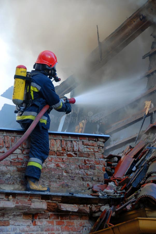 Firemen on a roof during a house fire. Firemen on a roof during a house fire.