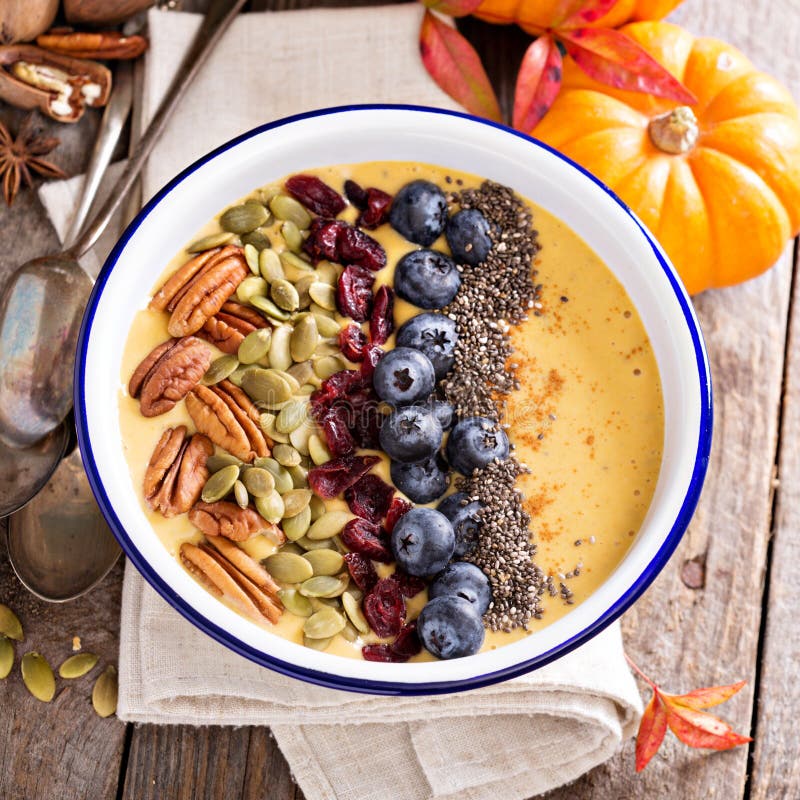 Pompoen smoothie kom met chiazaden, pecannoten, Amerikaanse veenbessen stock fotografie Pompoen smoothie kom met chiazaden, pecannoten, Amerikaanse veenbessen stock fotografie