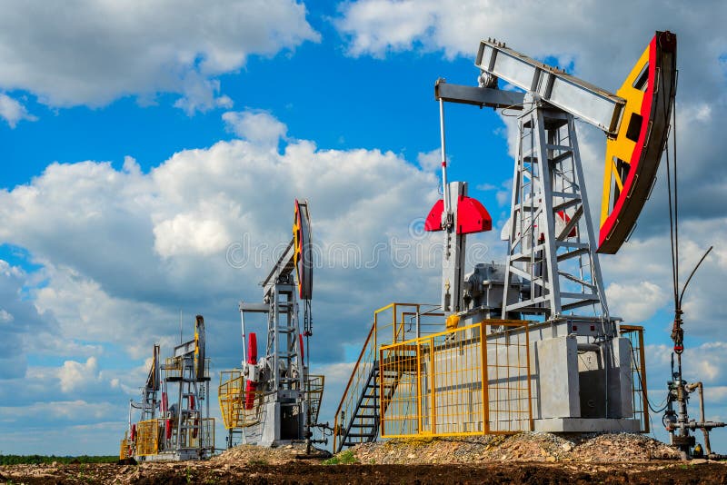 Pompstations voor olie en aardgasproductie tegen de wolkenhemel stock afbeeldingen Pompstations voor olie en aardgasproductie tegen de wolkenhemel stock afbeeldingen