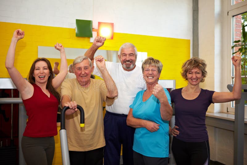 Mixed group with elderly people in a gym cheering. Mixed group with elderly people in a gym cheering